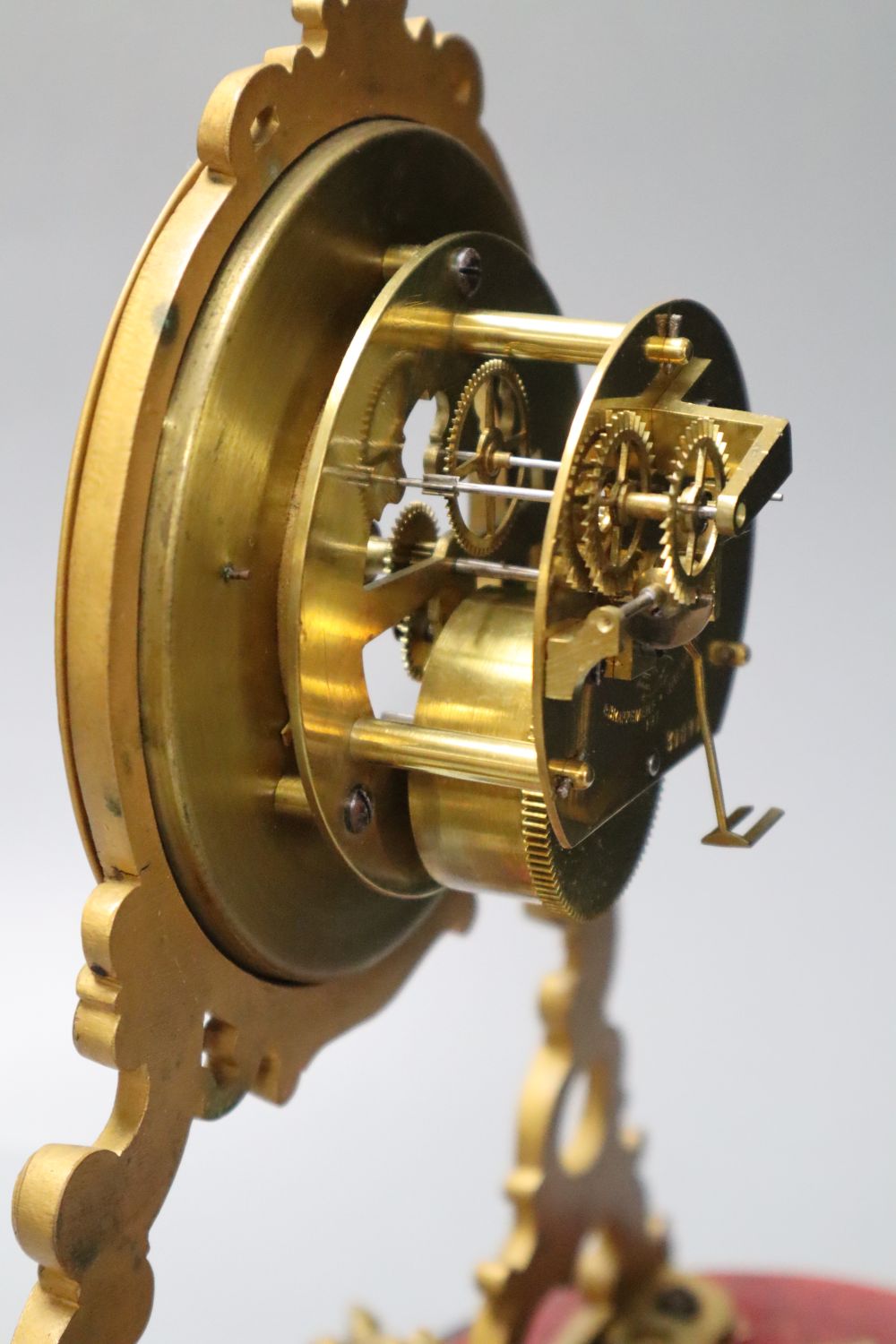A 19th century French swinging cherub mantel timepiece under glass dome, French movement with exposed escapement, 35cm high